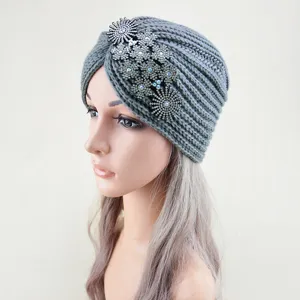 Detailed view of grey knit turban hat featuring sparkling rhinestone flower crystal side accessories.