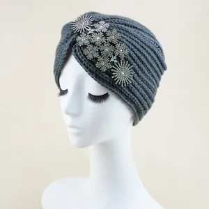 Detailed shot of dark grey knitted turban hat with sparkling crystal flower rhinestone decor.