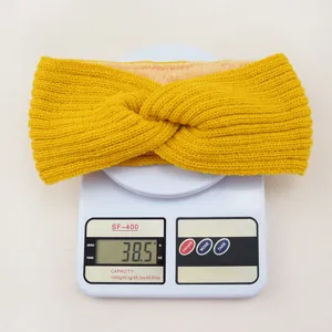 Close up of yellow knit fleece-lined twist headband detail showing plush interior texture.
