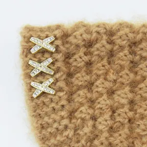Primo piano dettagliato di fascia in maglia marrone con bottoni scintillanti in strass a X.