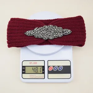 Vista dettagliata della fascia per capelli in maglia bordeaux con strass sulla bilancia