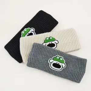 Vista dettagliata delle fasce in maglia a costole accoglienti con simpatici patch di cartoni.