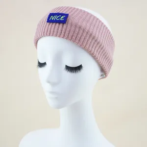 Pink knitted headband detail view, cozy winter hair accessory with blue NICE embroidery patch.