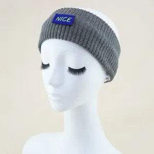 Grey knitted headband detail showing the embroidered NICE letter patch for winter warmth.
