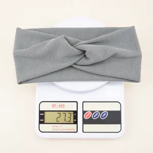 Close-up detail of grey ribbed knit twist headband, soft elastic hair band, daily wear accessories.