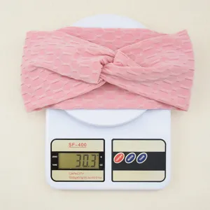 Detailed view of pink honeycomb textured twist headband, highlighting soft elastic fabric.