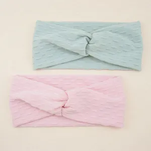 Detail view of stretchy athletic twisted yoga headbands with textured pattern for workout.