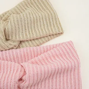 Vista detallada de diademas cruzadas de punto suave en beige y rosa, bandas elásticas de yoga.
