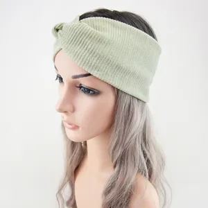 Close-up detail of the sparkling ribbed twist headband showing its wide metallic green fabric texture.