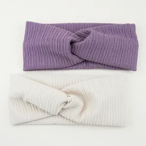 Detailed view of soft ribbed twist headbands in purple and beige, elastic wide hair band.