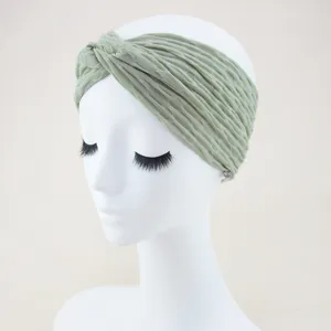 Green twist headband detail showing textured fabric on mannequin head for daily use.