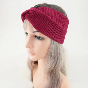 Detailed view of the dark red knitted cross headband worn on mannequin, soft texture.