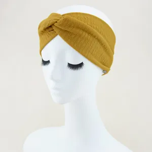 Textured mustard yellow twist headband detail close up view, soft elastic yoga hair accessory.