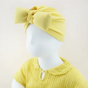 Gelbe Babymütze Detailansicht, süßes Schleifendesign, weicher Strickstoff für Kleinkinder.