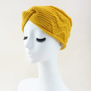Detail view of the yellow knitted cross headband, warm and cozy winter hair accessory.