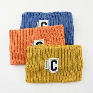Vue détaillée du bandeau tricoté avec patch lettre C, idéal pour le yoga ou le lavage du visage.