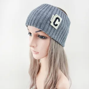 Vue détaillée de bandeau tricoté gris avec patch lettre C élégant et tissu confortable.