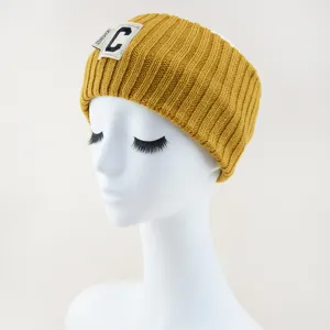 Bandeau tricoté jaune pour femme, large serre-tête hivernal avec patch C, accessoire chic.