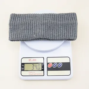 Grey knitted headband detail showing weight on scale, soft solid color ribbed hair accessory.