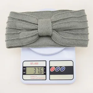 Grey knitted bow headband detail shot, warm wool hair accessory with stripe design, 37.6g.