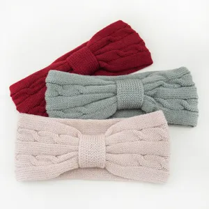 Close-up details of soft cable knit headband with cute bow, warm winter hair accessory.