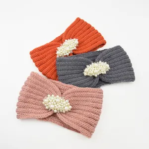 Vue détail du bandeau d'hiver tricoté avec une décoration élégante de perles et tissu chaud.