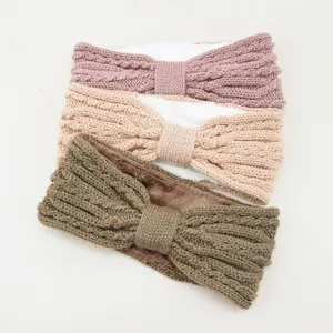 Close-up detail of cozy knit fleece-lined bow headband, soft warm ear warmer fabric texture.