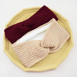 Detailed view of fleece-lined knitted criss-cross headband, winter warm hair accessory.