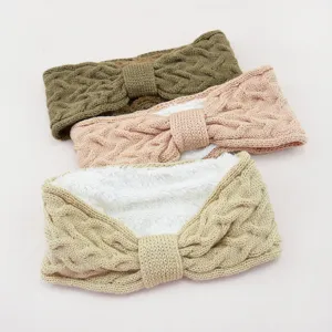 Detailed close-up of thick fleece-lined cable knit headband with cute bow for cold winter days.