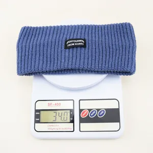 Blue knitted headband with black label, thick winter hair accessory for women daily wear.