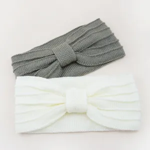 Knit bow headband detail view, soft woolen elastic hair band in grey and white colors.