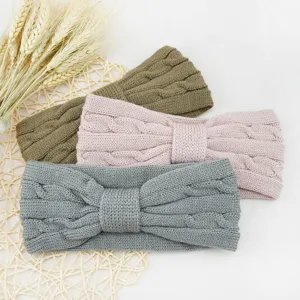 Knit headband detail view, cozy cable knit texture with bow design in soft neutral colors.