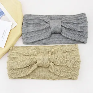 Detailed shot of double layer knitted bow headbands in grey and khaki colors, soft winter hair accessories.