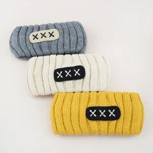 Knit headband set featuring cozy textured ribbed design and stylish embroidered cross accents.