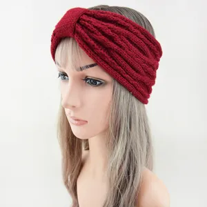 Close-up detail of a dark red knitted headband with a twist front design, cozy winter hair accessory.