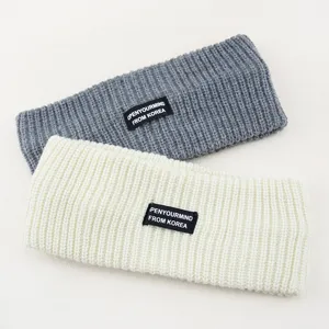 Close-up detail of soft ribbed knit hair band with label, cozy winter hair accessory.