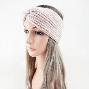 Close-up detail of the warm knit twisted headband in soft pastel pink color texture.