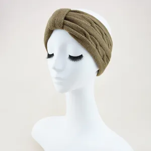 Detailed view of the khaki knitted twist headband, showing cable knit texture and knot design.
