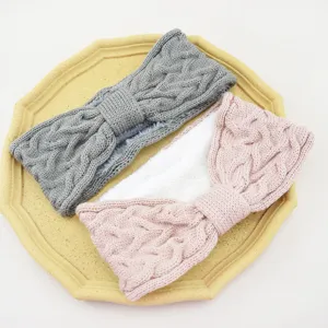 Detailed shot of fleece-lined knitted bow headband in grey and pink, warm ear warmer design.