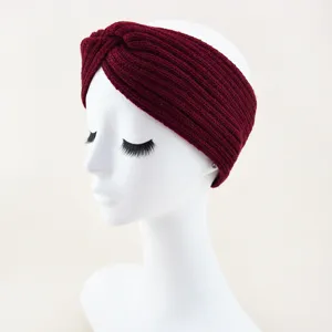 Close-up detail of the cozy winter knitted cross headband in rich burgundy knit texture.
