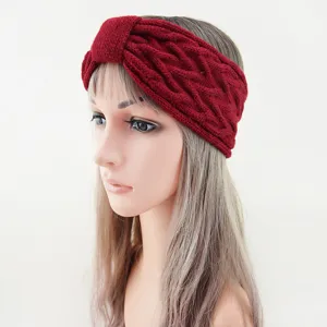Close-up detail of the dark red cable knit headband showing soft wool texture and bow.
