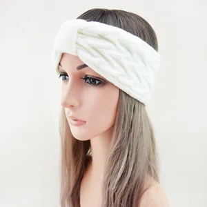 Detailed shot of a cozy white knitted headband with a stylish twist design for warm winter wear.