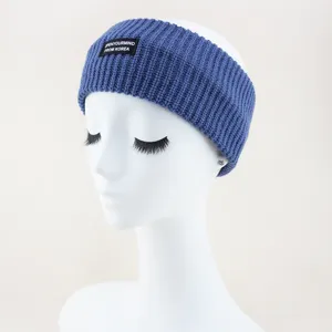 Blue knitted headband detail showing soft ribbed texture and stylish logo patch design.
