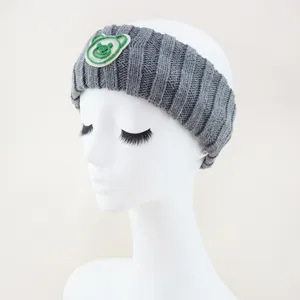 Close-up detail of grey knit headband featuring cute green bear patch for daily wear.