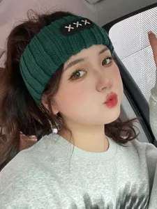 Green knitted headband for women, thick hairband with cute embroidery detail.