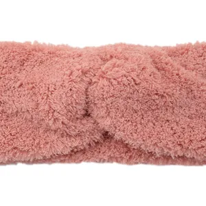 Nahaufnahme des weichen rosa Plüsch-Kopfbands mit Twist, kuscheliges Winter-Haaraccessoire.
