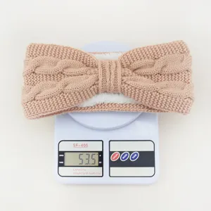 Knit bow headband detail showing winter fleece-lined ear warmer product weight on digital scale