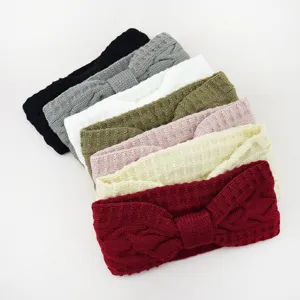 Vista dettagliata della fascia in maglia trecciata con fiocco, accessorio per capelli invernale.