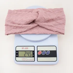 Detailed view of the pink bubble fabric criss-cross headband on a digital weighing scale.