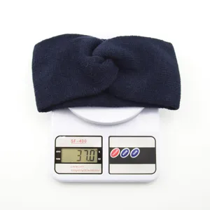 Detail view of dark blue knitted winter headband, soft wool fabric, warm ear warmer accessory.